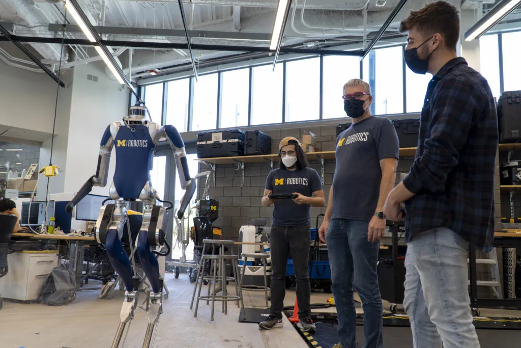 PhD student Bruce Huang and Professor Jessy Grizzle shows Popa-Simil how Digit can stand up.