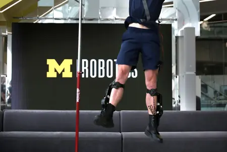 A track and field athlete jumps with the assistance of an ankle exoskeleton.