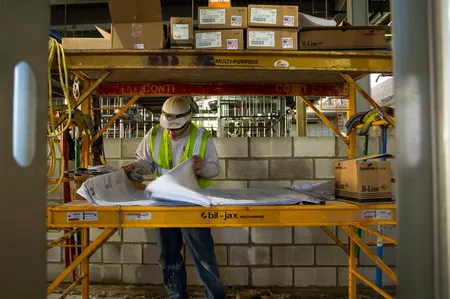 A construction worker reads plans.