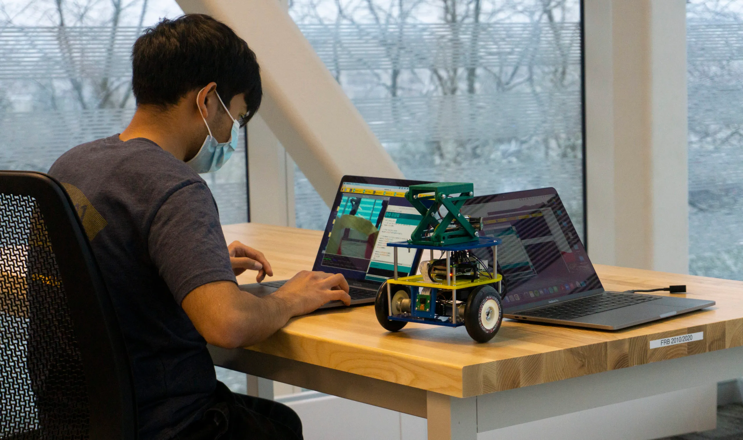A student checks a robot's code during the ROB 103 final competition.