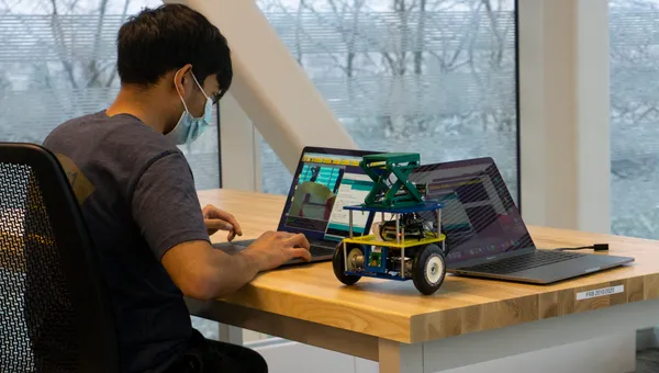 A student checks a robot's code during the ROB 103 final competition.
