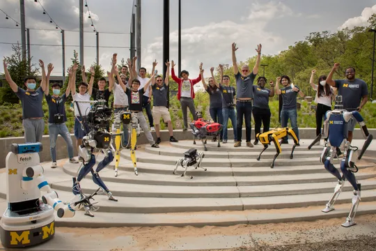 Robots and roboticists cheering in the Robot Garden. Photo by Robert Coelius.