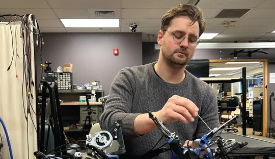 Thomas E Augenstein working with the Hand eMBot, his self-powered robot to improve post-stroke hand function.