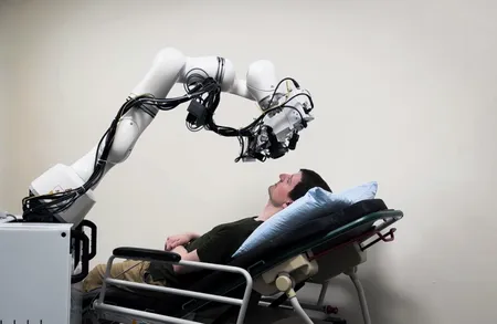 A research subject reclined on an exam bed with the eye imaging machine held in the proper place with a robot arm.