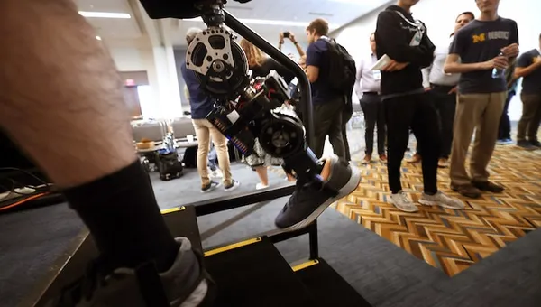 A student demonstrating a robotic prosthetic leg.