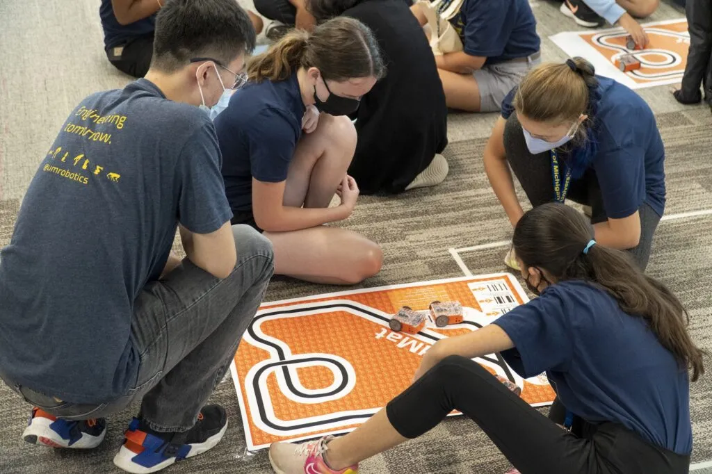 Bohao Zhang teaches Women in Science and Engineering summer camp students with Edison robots.